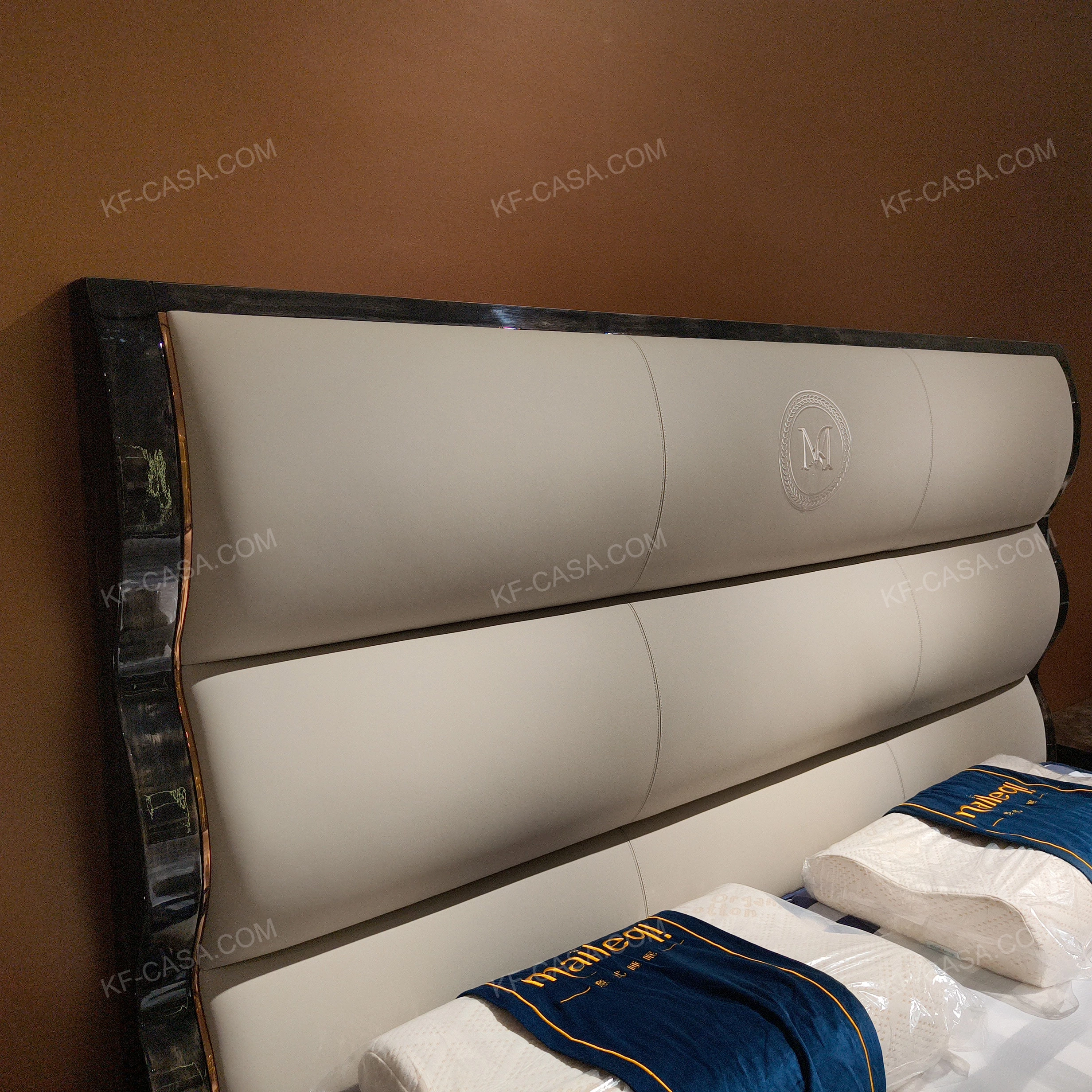 Soft Upholstered Bed with Embossed Brand Mark, Rich-Patterned Natural Wood Veneer Trim & Polished Gold Stainless Steel Accents